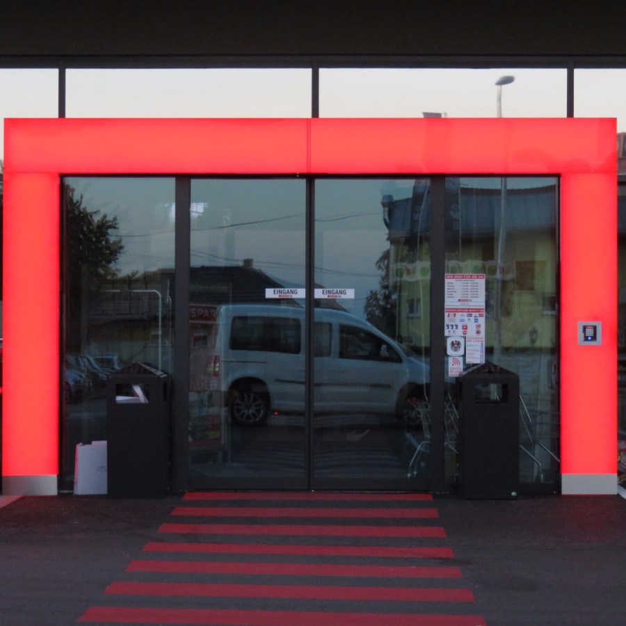Typischer Zugang in einen SPAR-Einkaufsmarkt mit roter Umrahmung des Eingangs und dem SPAR-Logo darüber - auch beim BSC Top-Projekt