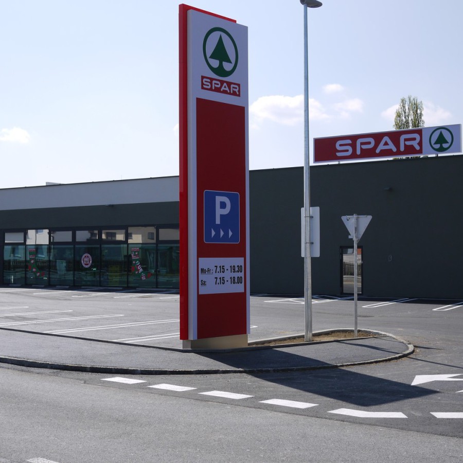 Standlogo mit Parkplatzschild und SPAR-Logo bei der Einfahrt auf das Gelände